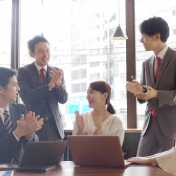 Group of business people in suits clapping in a business meeting